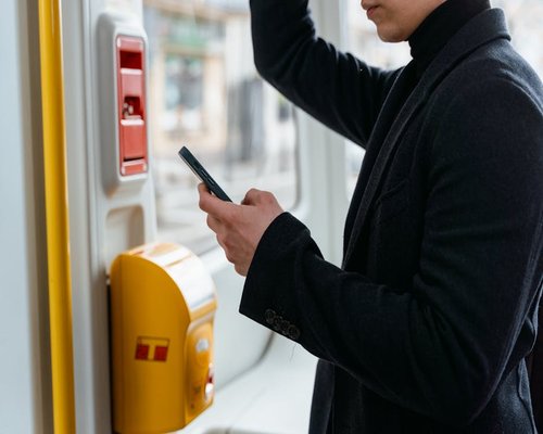 Person holding a smartphone in daily commute